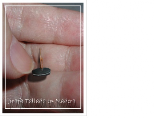 Jirafa, miniatura tallada en madera, con sus cuatro patas torneadas y su cuello de menos de 1mm. de diámetro y  se puede comprobar su diminuto tamaño con la imagen comparada que escala con la uña del dedo. - 24 Mar 2009